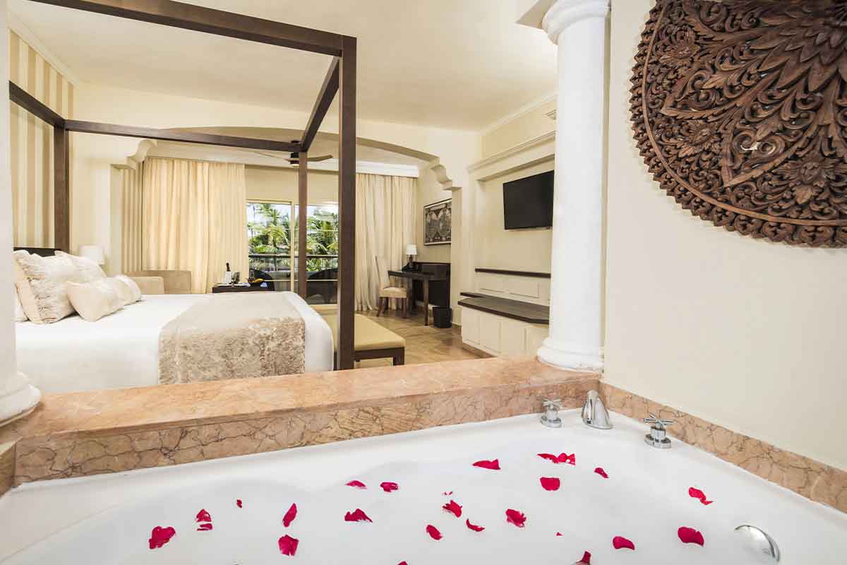 Jacuzzi en interior de habitación con petalos de rosa