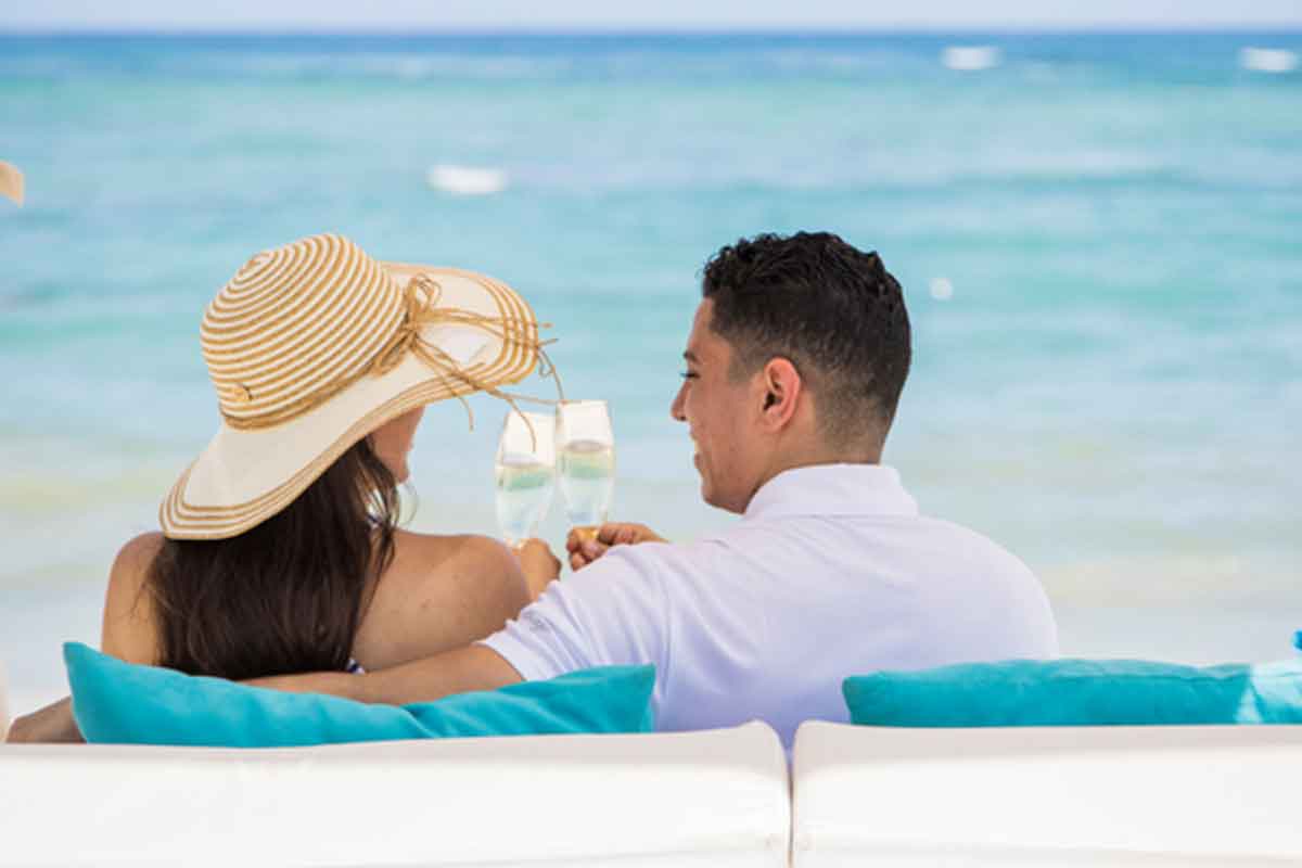 Pareja brindado con champan frente al mar