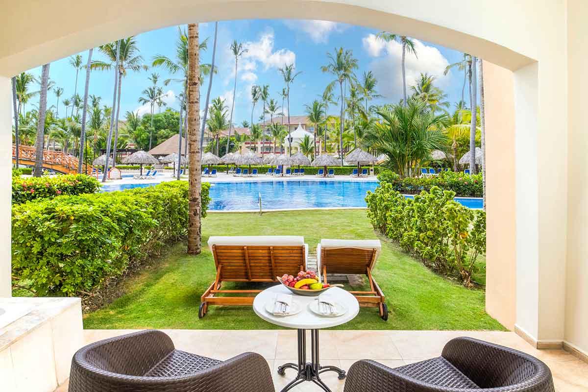 Terraza amueblado con sillas y hamacas con vistas a los jardines y piscina