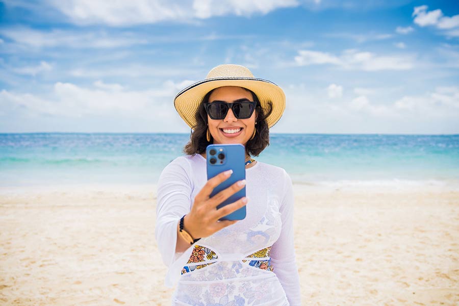Mujer tomándose un selfie en la playa Majestic Elegance Costa Mujeres 