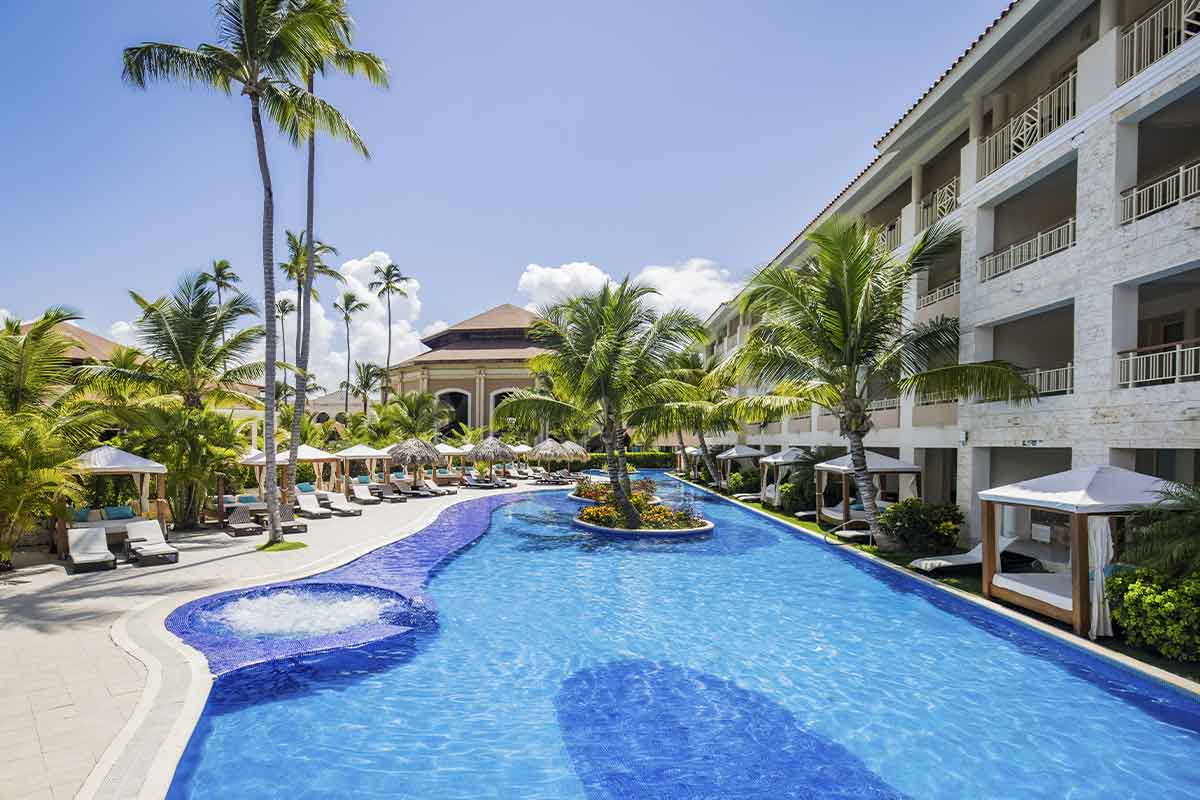 Gran piscina rodeada de palmeras en el Majestic Mirage Punta Cana