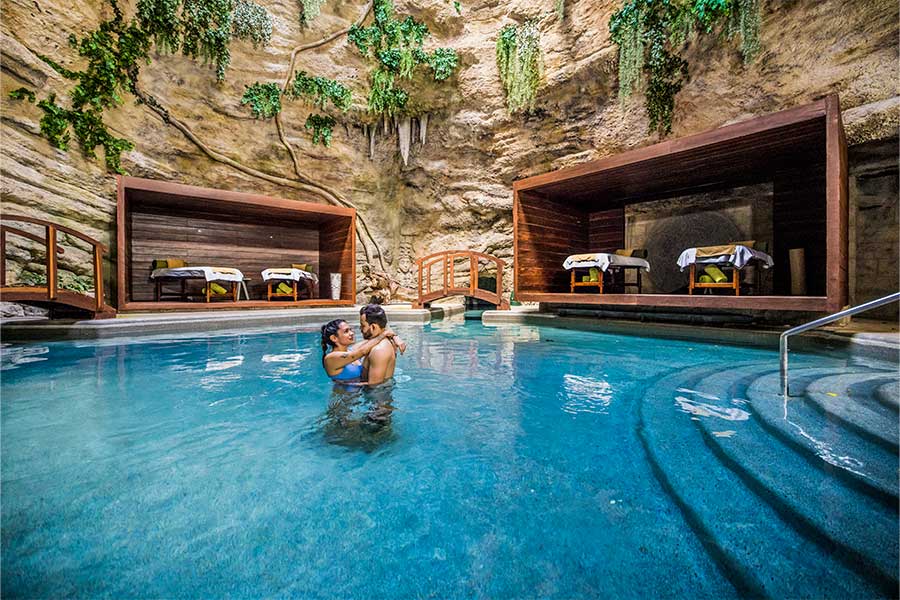 Pareja en la piscina de la zona de tratamientos Majestic Elegance Costa Mujeres