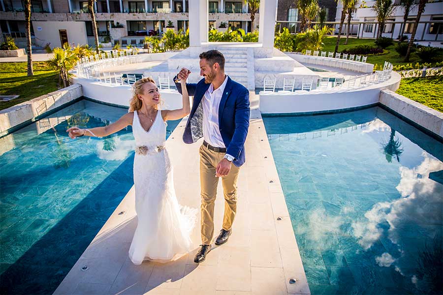 Novios paseando por el puente que conecta al altar  Majestic Elegance Costa Mujeres