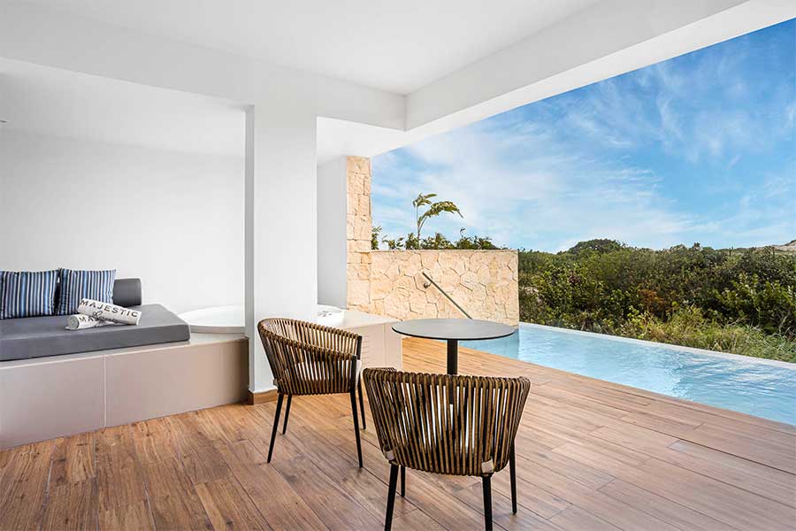 terraza con sillas y piscina elegance club junior suite swim up
