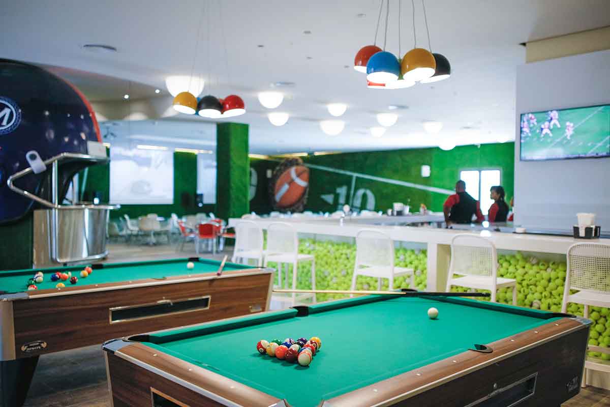 Bar con temática deportiva equipado con billares y televisores para ver deportes
