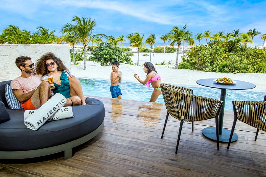 familia disfrutando de la piscina swim up suite frente a la playa
