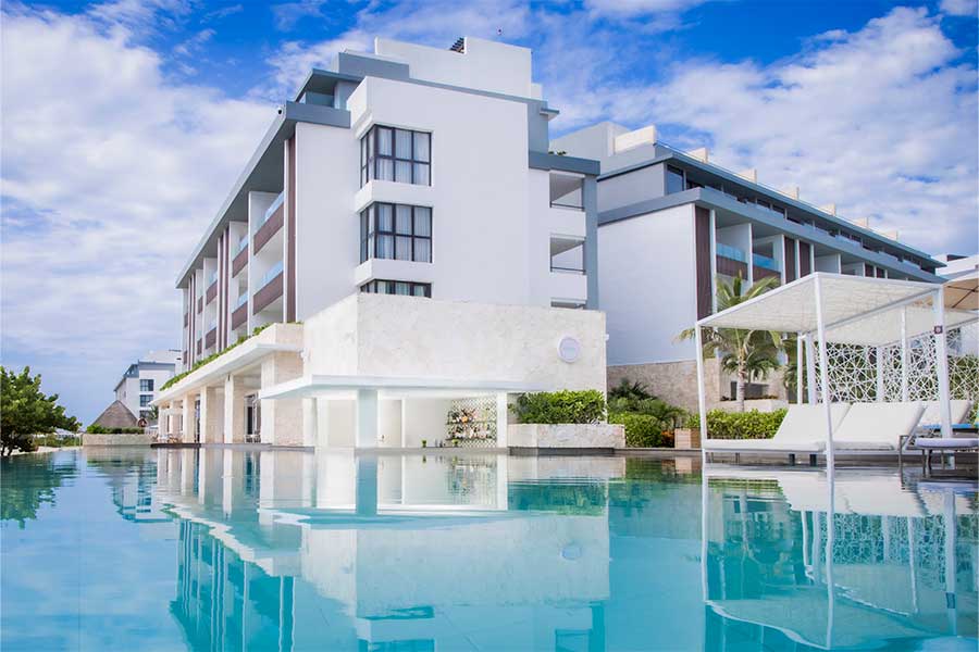 Piscina rodeando el edificio con camas balinesas Majestic Elegance Costa Mujeres